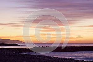 Sunrise seascape on Cubelles shore with Vilanova i la Geltru on background photo