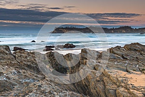 Sunrise seascape with rocks and low cloud bank