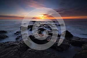 Sunrise seascape from a rocky Jetty