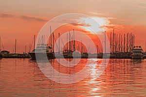 Sunrise on the seashore. In the silhouette of the ships in the harbor. Selective focus