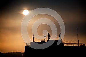 Sunrise with silhouettes of communication antenna with an array of dishes