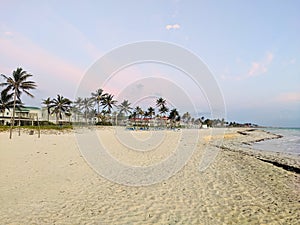 Sunrise of the sun with pink clouds on the sandy beach near the ocean. Cayo Coco, Cuba photo