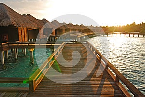 Sunrise with sunlight falling on the overwater villa at a tropical resort island, Maldives