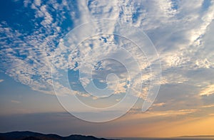 Sunrise, sunset clouds over land silhouette and sea. Twilight, dusk cloudy sky