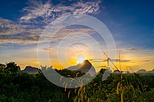 Sunrise or sunset light over mountains with grass in the foreground Low angle view, Amazing colorful sky clouds background