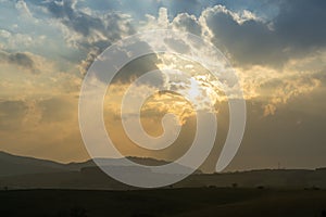 Sunrise or sunset over the hills and meadow.