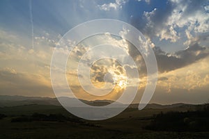 Sunrise or sunset over the hills and meadow.