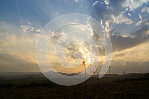 Sunrise or sunset over the hills and meadow.