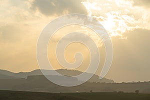 Sunrise or sunset over the hills and meadow.