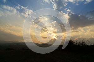 Sunrise or sunset over the hills and meadow.