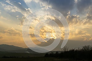 Sunrise or sunset over the hills and meadow.