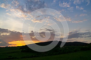 Sunrise or sunset over the hills and meadow.