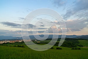 Sunrise or sunset over the hills and meadow.