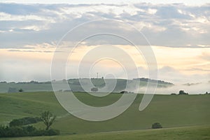 Sunrise or sunset over the hills and meadow.