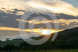 Sunrise or sunset over the hills and meadow.