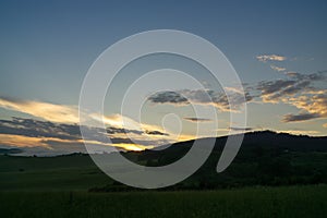 Sunrise or sunset over the hills and meadow.