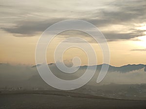 Sunrise or sunset over the hills and meadow.