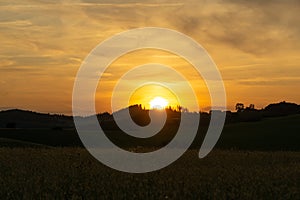 Sunrise or sunset over the hills and meadow.