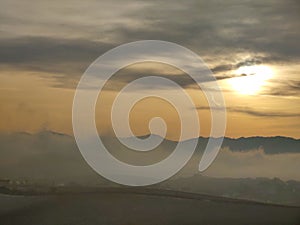 Sunrise or sunset over the hills and meadow.