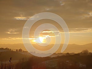 Sunrise or sunset over the hills and meadow.