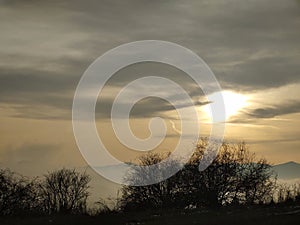 Sunrise or sunset over the hills and meadow.