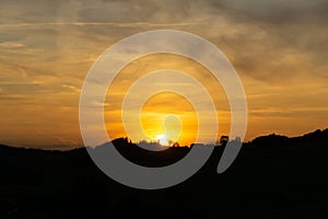 Sunrise or sunset over the hills and meadow.