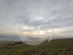 Sunrise or sunset over the hills and meadow.