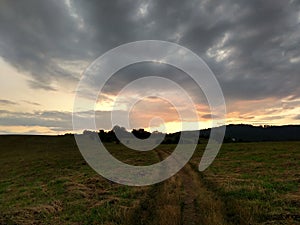 Sunrise or sunset over the hills and meadow.