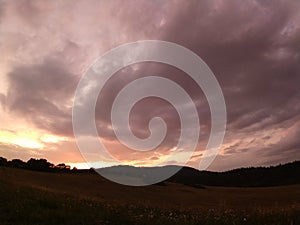 Sunrise or sunset over the hills and meadow.