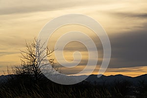 Sunrise or sunset over the hills and meadow.