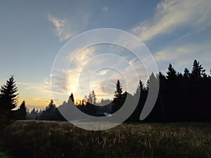 Sunrise or sunset over the hills and meadow.