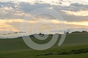 Sunrise or sunset over the hills and meadow.