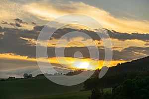 Sunrise or sunset over the hills and meadow.