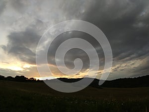 Sunrise or sunset over the hills and meadow.