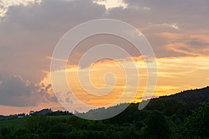 Sunrise or sunset over the hills and meadow.