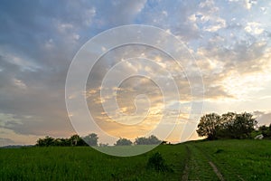 Sunrise or sunset over the hills and meadow.