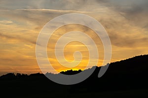 Sunrise or sunset over the hills and meadow.