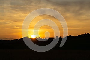 Sunrise or sunset over the hills and meadow.