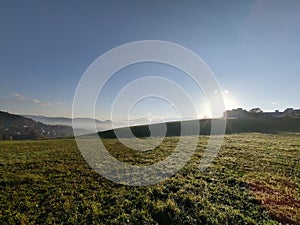 Sunrise or sunset over the hills and meadow.