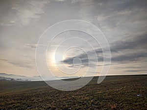 Sunrise or sunset over the hills and meadow.