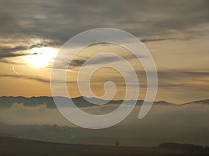 Sunrise or sunset over the hills and meadow.