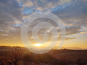 Sunrise or sunset over the hills and meadow.