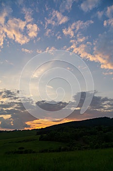 Sunrise or sunset over the hills and meadow.