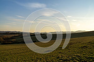 Sunrise or sunset over the hills and meadow.