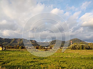 Sunrise or sunset over the hills and meadow.