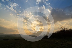 Sunrise or sunset over the hills and meadow.