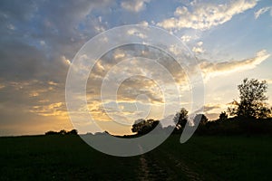 Sunrise or sunset over the hills and meadow.