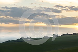 Sunrise or sunset over the hills and meadow.