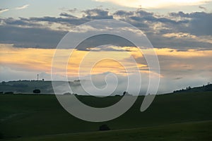 Sunrise or sunset over the hills and meadow.