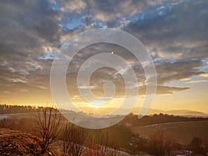 Sunrise or sunset over the hills and meadow.